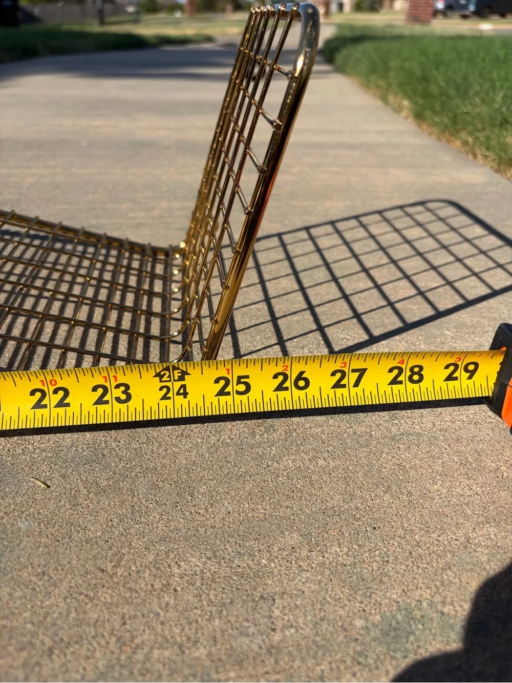 IKEA Svenshult gold-finished wire mesh wall shelf.